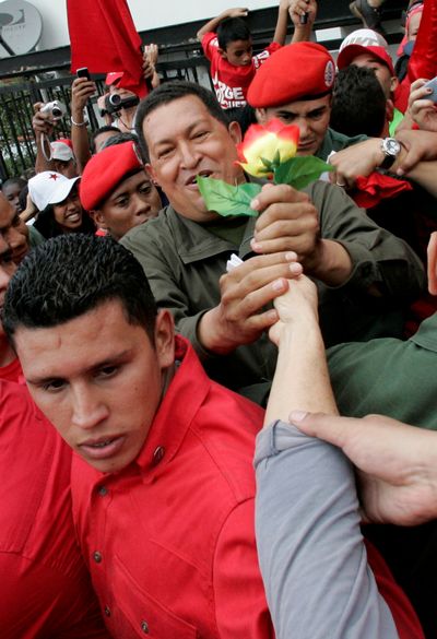 Venezuela’s President Hugo Chavez, center, is greeted by a supporter during a rally in Caracas on Friday.  (Associated Press / The Spokesman-Review)