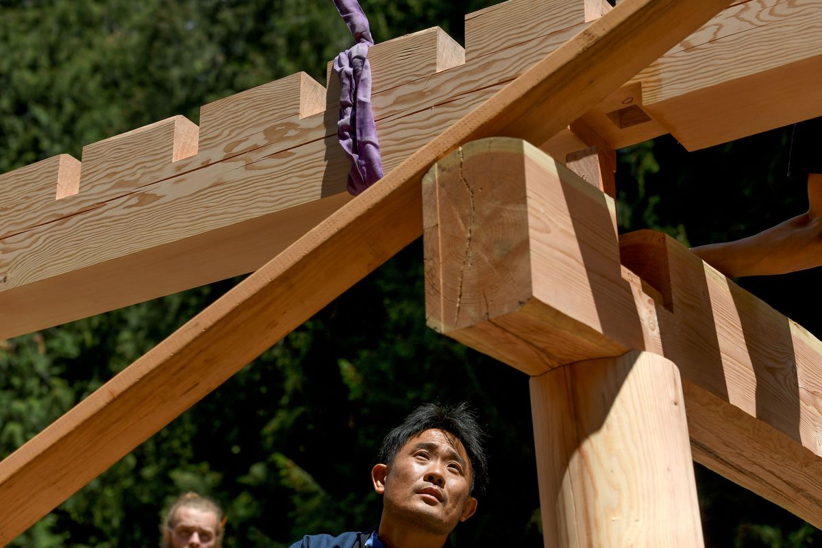 Woodworkers from around the United States and Japanese timber framer Kohei Yamamoto, right, are building a beautiful wooden bell tower to house a new bell sculpted by artist Mark Kubiak in Sandpoint on Friday, June 16, 2023.  (Kathy Plonka/The Spokesman-Review)