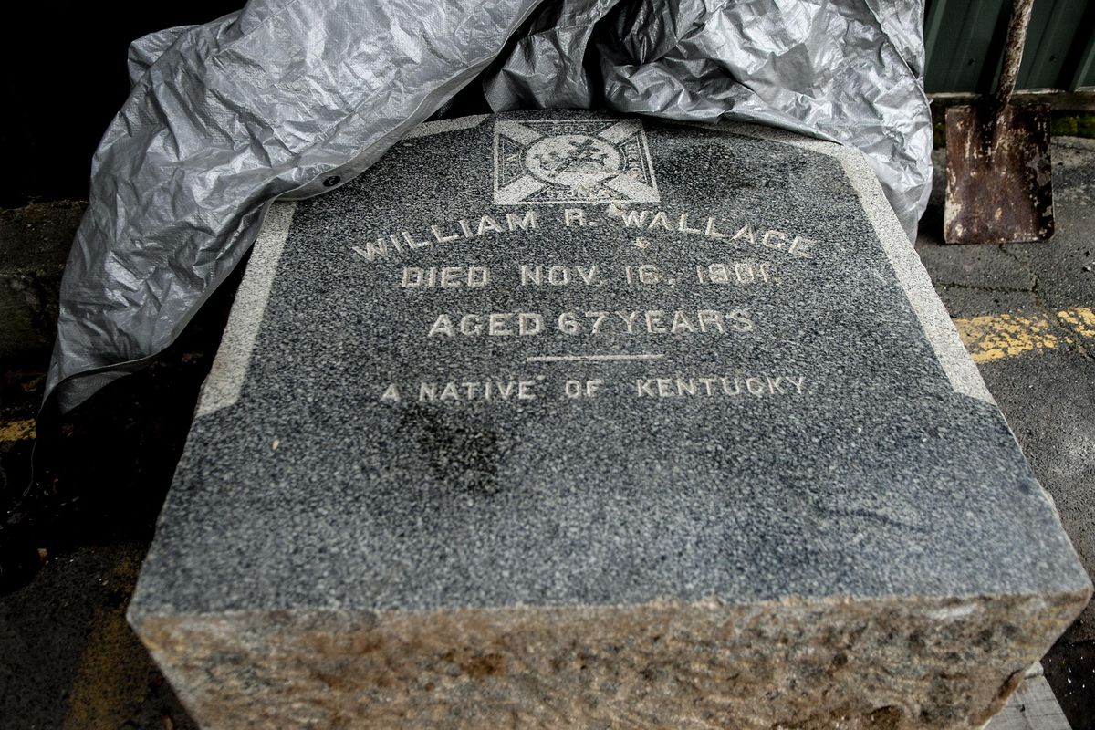 The tombstone of Col. William Wallace, the founder of Wallace, sits across the street from the Red Light Garage in Wallace. (Kathy Plonka / The Spokesman-Review)
