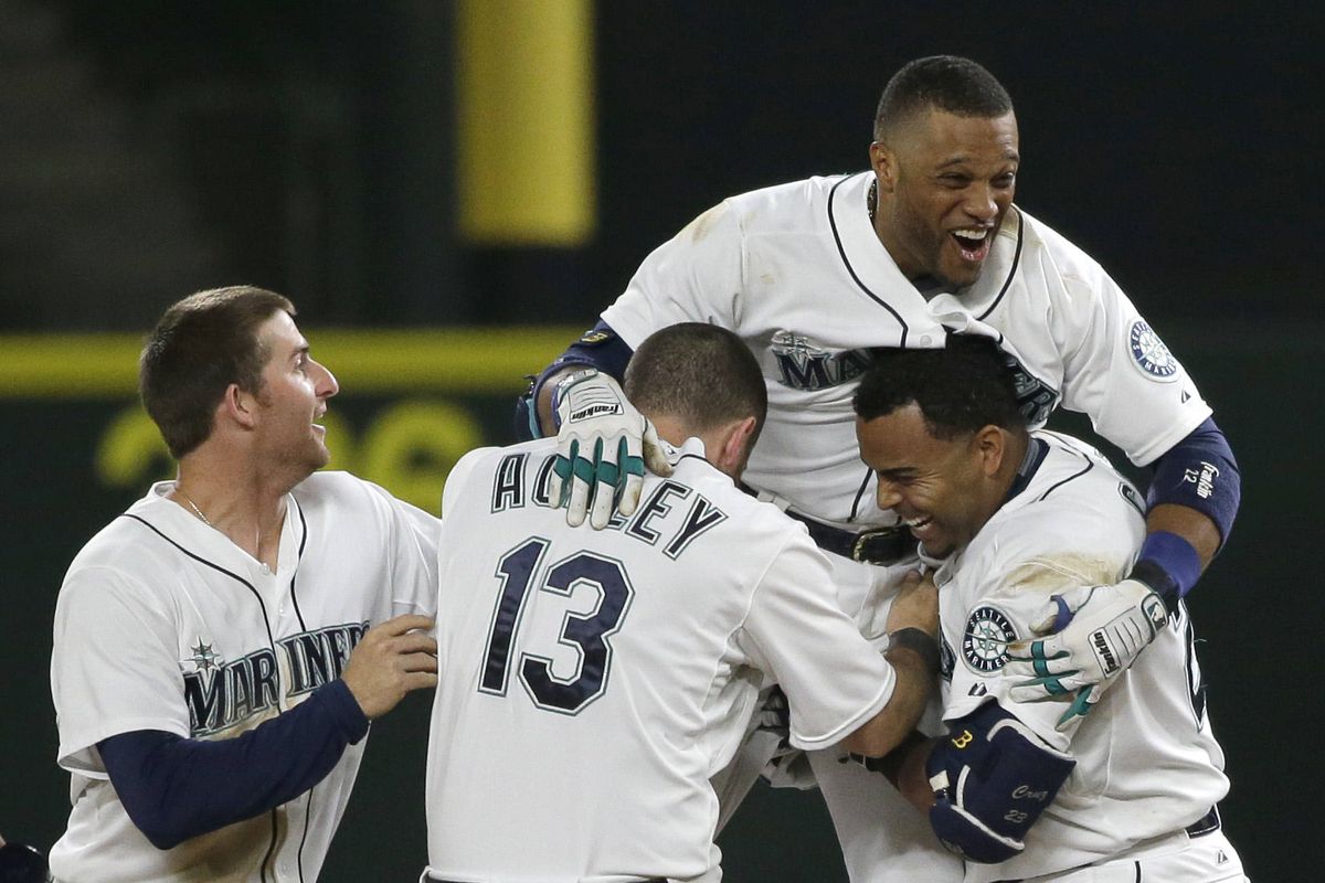 Seattle Mariners 2B Robinson Cano is lifted by teammates after driving in the winning run with a single in the 11th inning on Tuesday. (Associated Press)