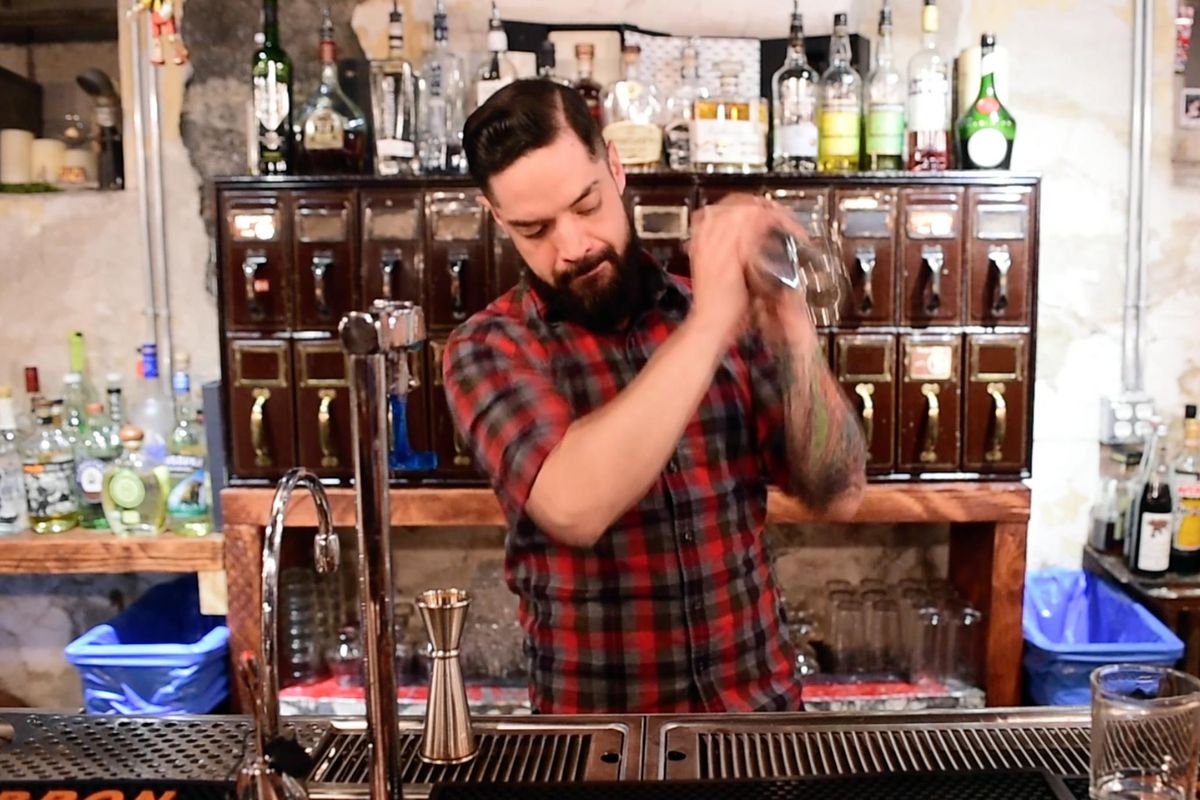 Bartender Simon Moorby vigorously shakes the egg white and flavor agents to turn the mixture into a meringue, fluffy and well aerated, one of the first steps to producing a classic Whiskey Sour at Hogwash Whiskey Den in Spokane Tuesday, May 16, 2017. (Jesse Tinsley / The Spokesman-Review)