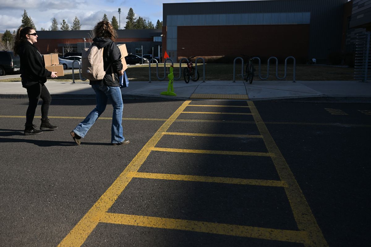 Volunteer Krystal Allison, left, and Angella Southerly, right, with Project Lift Up, carry boxes containing hand-packed mental health care kits on Friday, March 31, 2023, to Northwood Middle School in Spokane, Wash.  (Tyler Tjomsland/The Spokesman-Review)
