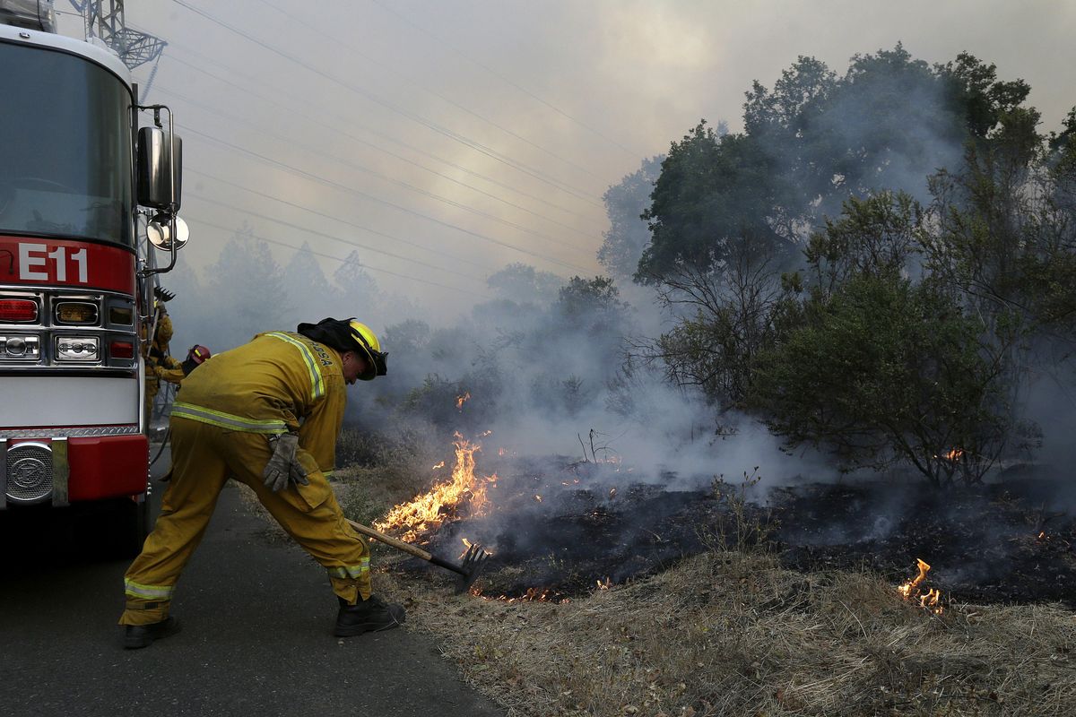 Santa Rosa firefighters work on a fire on the side of a road near the Oakmont area in Santa Rosa, Calif., Tuesday, Oct. 10, 2017. (Jeff Chiu / Associated Press)