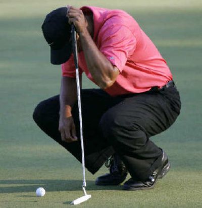 
Tiger Woods bows his head on the 15th hole prior to making his birdie putt. 
 (Associated Press / The Spokesman-Review)