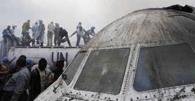 Rescue workers and onlookers gather at the site of a plane crash in Goma, Congo, on Tuesday. Smoke engulfed the charred ruins of the aircraft, which appeared to have broken in two. Associated Press
(Associated Press / The Spokesman-Review)