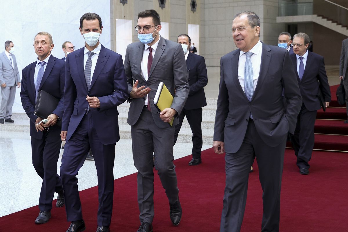 In this photo released by Russian Foreign Ministry Press Service, Russian Foreign Minister Sergey Lavrov, right, and Syrian President Bashar al-Assad, second left, walk after their talks in Damascus, Syria, Monday, Sept. 7, 2020. Russia