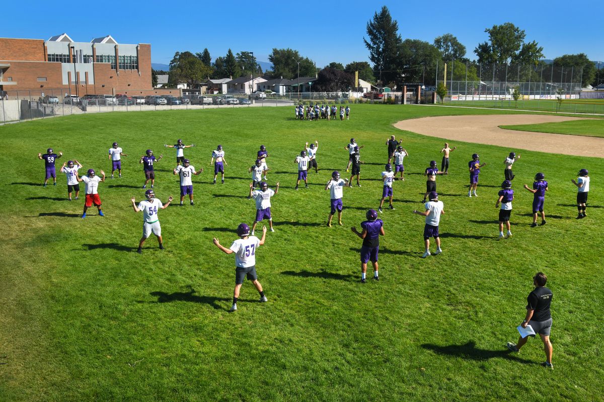 Rogers High School varsity and freshmen teams warm up before practice, Wednesday, Aug. 4, 2019. Coach David Chambless, lower right, says he has about 50 players and needs 15 to 20 more. But he said it’s not an excuse. “Our philosophy is that we’re going to win with the kids we’ve got,” he said. (Dan Pelle / The Spokesman-Review)