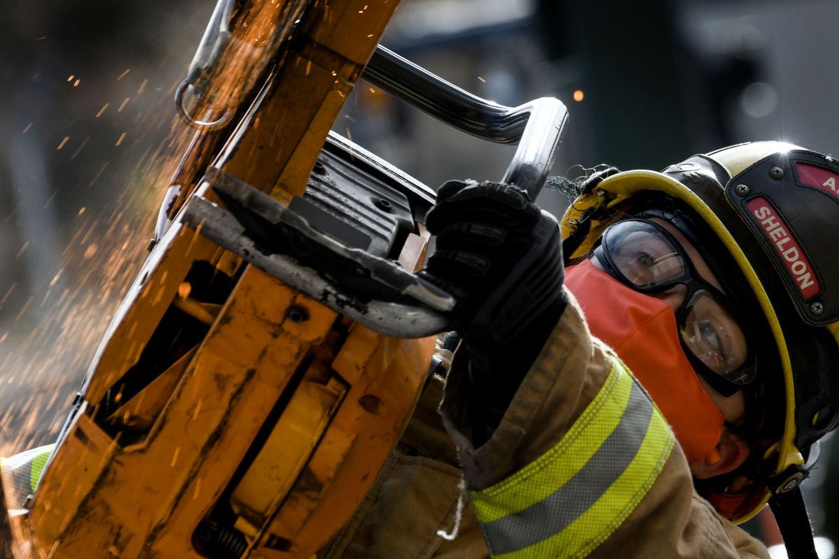 Firefighter Krista Sheldon of Albany, Oregon, saws through a piece of steel rebar during the International Women in Fire conference in Spokane on Wednesday.  (Kathy Plonka/The Spokesman-Review)
