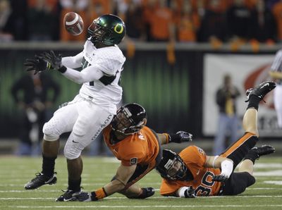 Every bounce seemed to favor the Ducks as Jeremiah Johnson bobbles the ball during his 83-yard TD run.  (Associated Press / The Spokesman-Review)