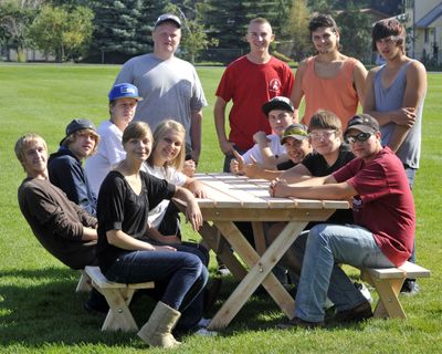 A team of students gather around a picnic table and bench they built during their East Valley High School construction class on Friday in Spokane Valley. (Dan Pelle)
