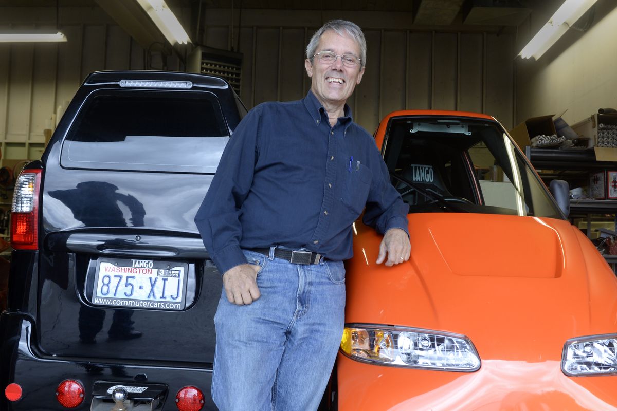 Rick Woodbury stands with two of his Tango commuter cars Wednesday at his Spokane headquarters. (Jesse Tinsley)