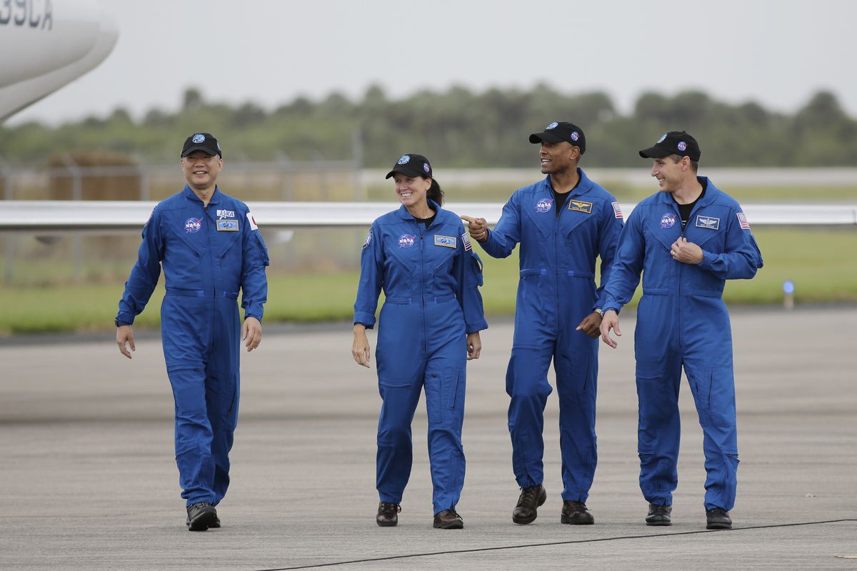 From left, astronaut Soichi Noguchi, of Japan, and NASA astronauts Shannon Walker, Victor Glover and Michael Hopkins walk after arriving at Kennedy Space Center on Sunday in Cape Canaveral, Fla.  (Terry Renna)