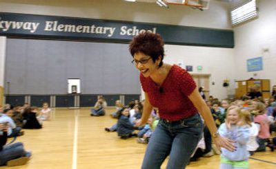 
P.E. teacher Teri Hamilton runs around the gym and models her red-dyed hair for the student body at Skyway Elementary where she challenged her students to raise $3,000 during the Jump Rope for Heart fund-raiser for the American Heart Association and in return she would dye her hair.
 (Jesse Tinsley / The Spokesman-Review)