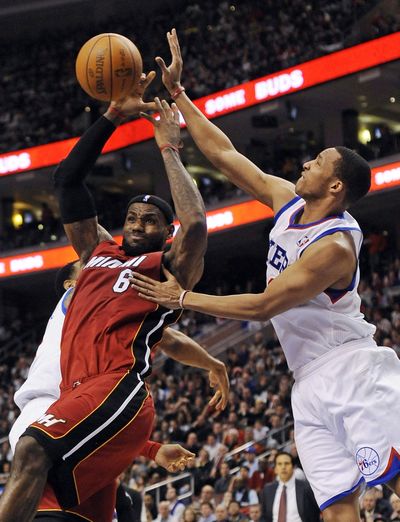 Miami Heat’s LeBron James, left, is fouled by Philadelphia 76ers’ Evan Turner. James had 19 points and 12 rebounds. (Associated Press)