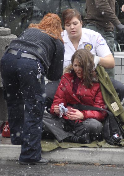 Emergency personnel attend to a woman who was hit by an STA bus as she crossed Monroe at Sprague early Friday afternoon.  (Colin Mulvany / The Spokesman-Review)