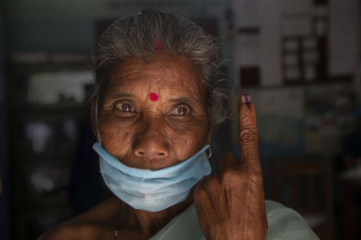 An elderly tribal Mishing displays the indelible ink on her finger after casting her vote at a polling center during the first phase of Assam state elections in Majuli, India, Saturday, March 27, 2021. Voting began Saturday in two key Indian states with sizeable minority Muslim populations posing a tough test for Prime Minister Narendra Modi’s popularity amid a months-long farmers’ protest and the economy plunging with millions of people losing jobs because of the coronavirus pandemic.  (Anupam Nath)