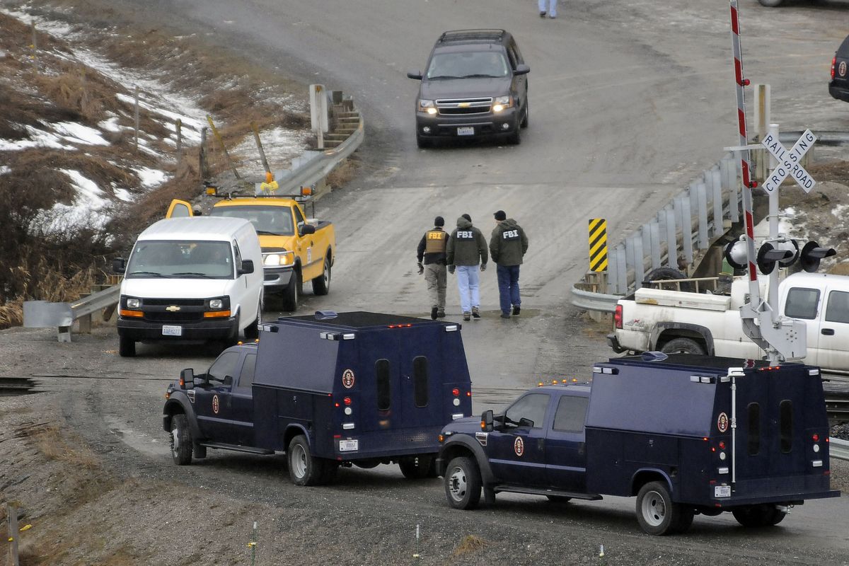FBI agents cross the bridge on 12 Mile Road during their investigation of Kevin Harpham on March 9, 2011, near Addy, Wash. (File)