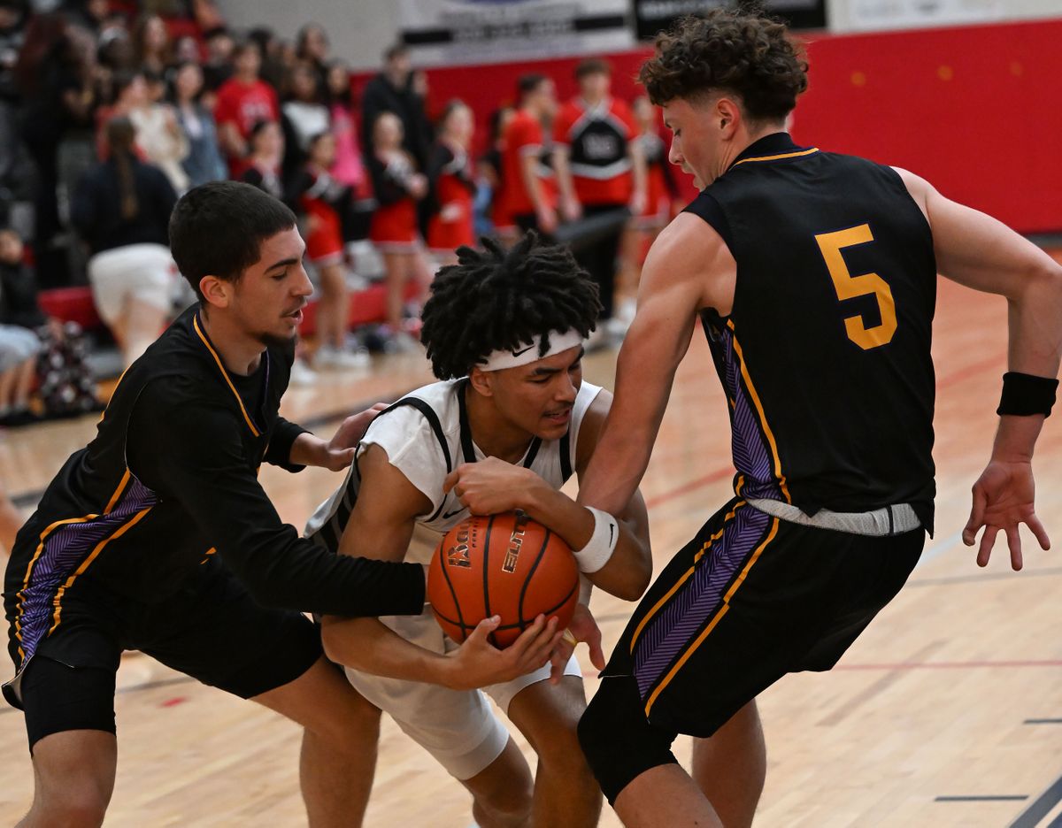 Rogers guard Davontae Muhammad Jr. on left, and guard Alex N Peabody, on right, try to strip the ball from North Central guard Isaac Williams during a GSL boys high school game, Friday, Jan. 2, 2025, at North Central High School.  (COLIN MULVANY/THE SPOKESMAN-REVIEW)