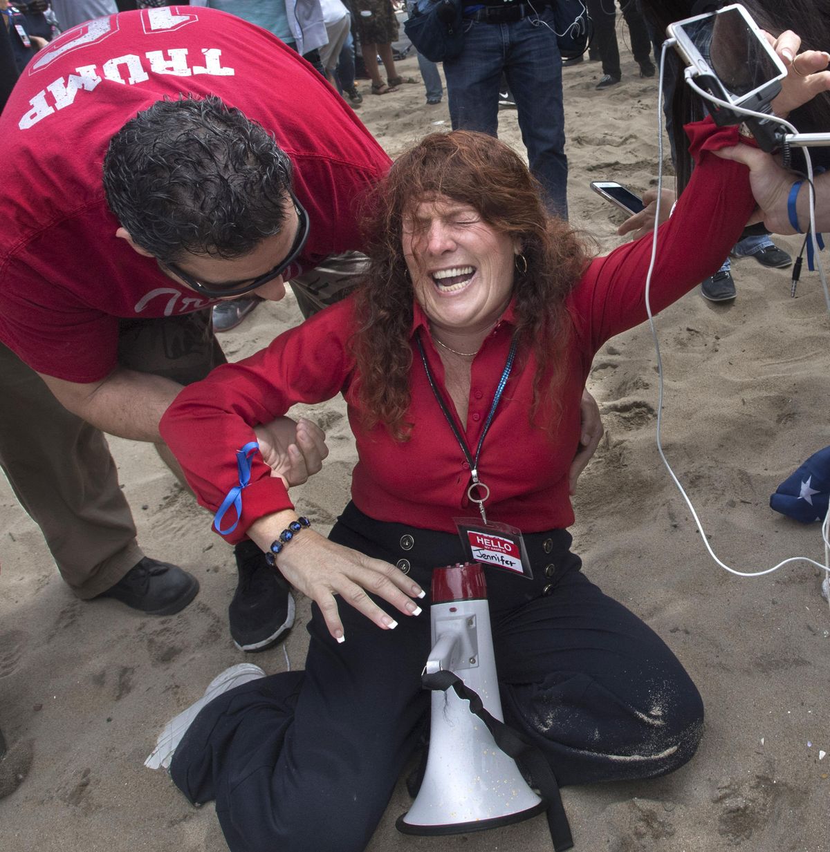 Jennifer Sterling, one of the organizers of the pro-Donald Trump rally, reacts after getting hit with pepper spray in Huntington Beach, Calif., on Saturday. Violence erupted when a march of about 2,000 Trump supporters at Bolsa Chica State Beach reached a group of about 30 counter-protesters, some of whom began spraying pepper spray, said Capt. Kevin Pearsall of the California State Parks police. (Mindy Schauer / Associated Press)
