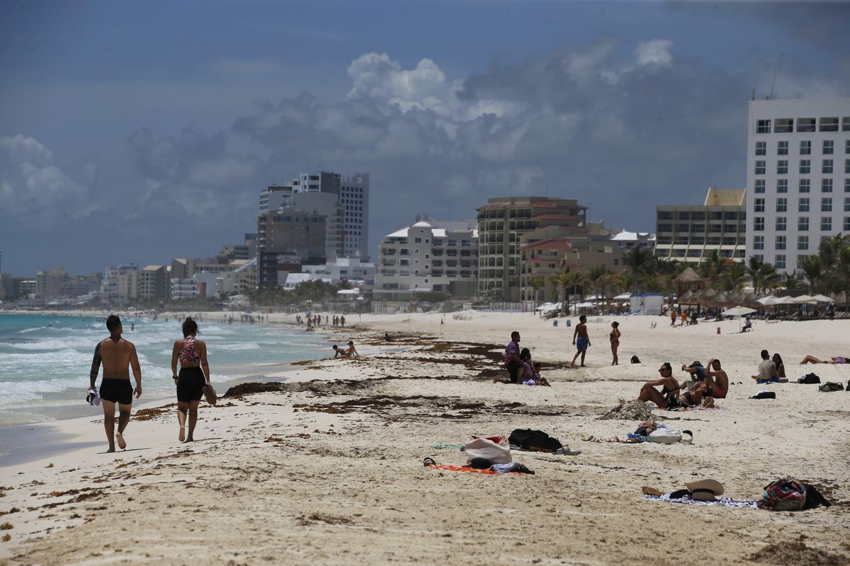 Tourists enjoy the beach before the arrival of Hurricane Grace, in Cancun, Quintana Roo State, Mexico, Wednesday, Aug. 18, 2021. Residents and tourists along the Caribbean coast began making preparations for Grace, a storm that drenched Haiti and Jamaica and is now forecast to hit Mexico´s Yucatan peninsula like a hurricane early Thursday morning.  (Marco Ugarte)