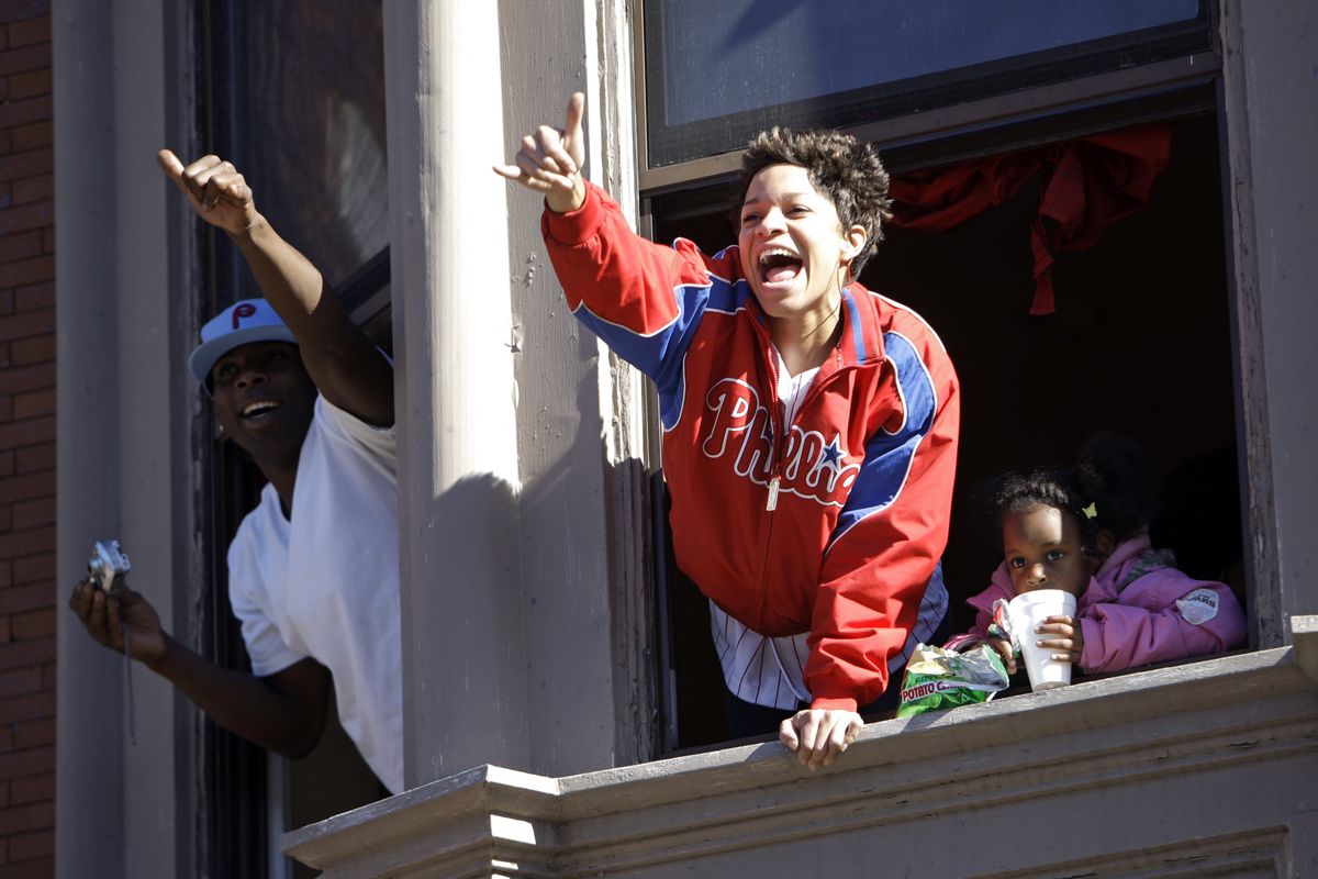 Fans gesture to Philadelphia’s Shane Victorino as the Phillies head down Broad Street. (Associated Press / The Spokesman-Review)