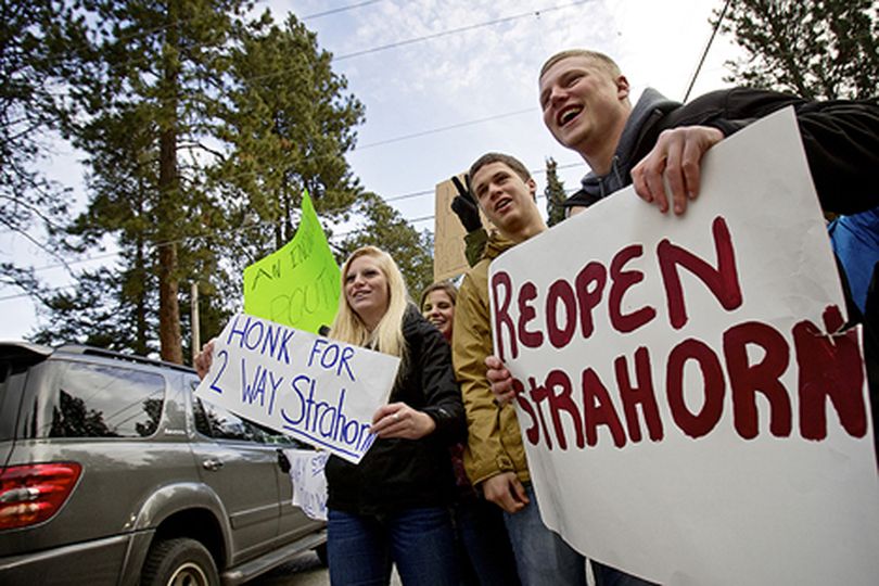 Jeremiah Hazard, right, Matt Humphries and Patricia Eastman, all 17, protest Monday with their Coeur d'Alene High AP Government  classmates at the corner of Strahorn Road and Hayden Avenue in Hayden Lake. (Jerome Pollos/press)