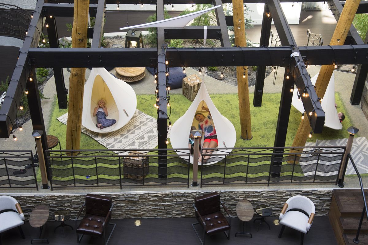 In the lobby of the newly renovated Hotel RL by Red Lion, hotel  guests lounge in cocoons hanging from a pergola. The downtown hotel, along the north bank of the Spokane River, has been remade to be more inviting to guests and the community. (Colin Mulvany / The Spokesman-Review)