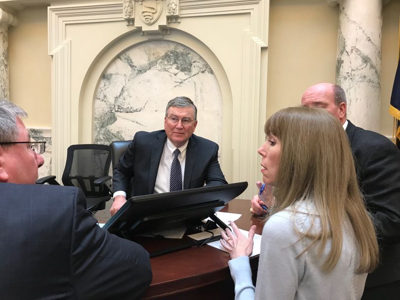 House Speaker Scott Bedke, center, confers with Rep. Lynn Luker, left, House chief clerk Carrie Maulin, and House Majority Leader Mike Moyle, right, on technical questions about how the House will end its session this year, on Wednesday, March 22, 2018; lawmakers are hoping to adjourn this year's session by Friday. (The Spokesman-Review / Betsy Z. Russell)