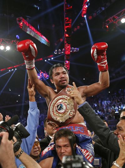 Manny Pacquiao dons champion's belt after beating Brandon Rios. (Associated Press)