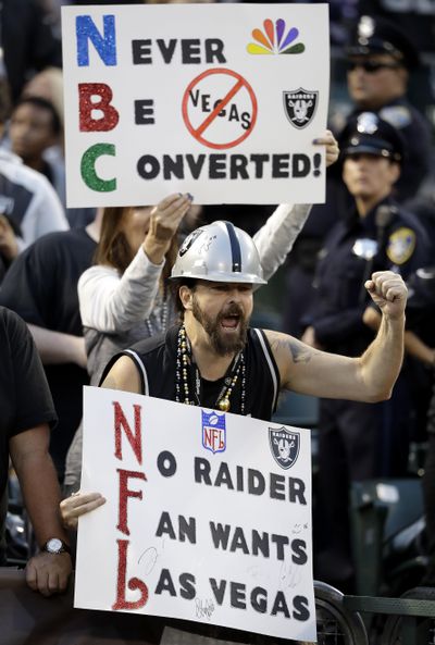 In this Nov. 6, 2016, file photo, Oakland Raiders fans hold up signs about the team's possible move to Las Vegas during an NFL football game between the Raiders and Denver Broncos in Oakland, Calif. The Oakland Raiders have filed paperwork to move to Las Vegas. Clark County Commission Chairman Steve Sisolak told The Associated Press on Thursday, Jan. 19, 2017, that he spoke with the Raiders. (Marcio Jose Sanchez / Associated Press)