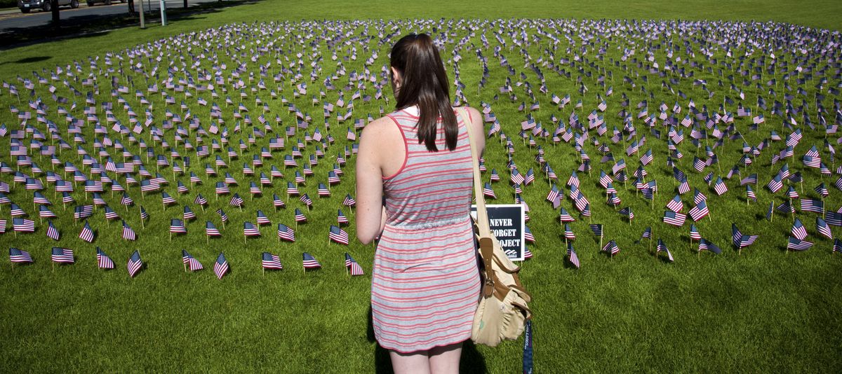 Gonzaga University student Emily Dittig, a junior from Bellevue, calls her father as she pauses to view a campus display of flags Friday. Each flag represents an individual who was killed in the 9/11 attacks. Dittig said the display reminded her of Arlington National Cemetery in Arlington, Va., which she will visit soon to bury her late grandmother, who was an Army nurse in World War II. The “9/11: Never Forget Project” was presented by the Gonzaga University College Republicans. (Dan Pelle)