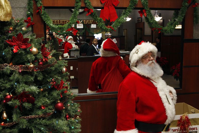  Freelance Santa John Wenner  waits to greet people last week  in Philadelphia. Wenner says he’s reduced his fee to help business.  (Associated Press)