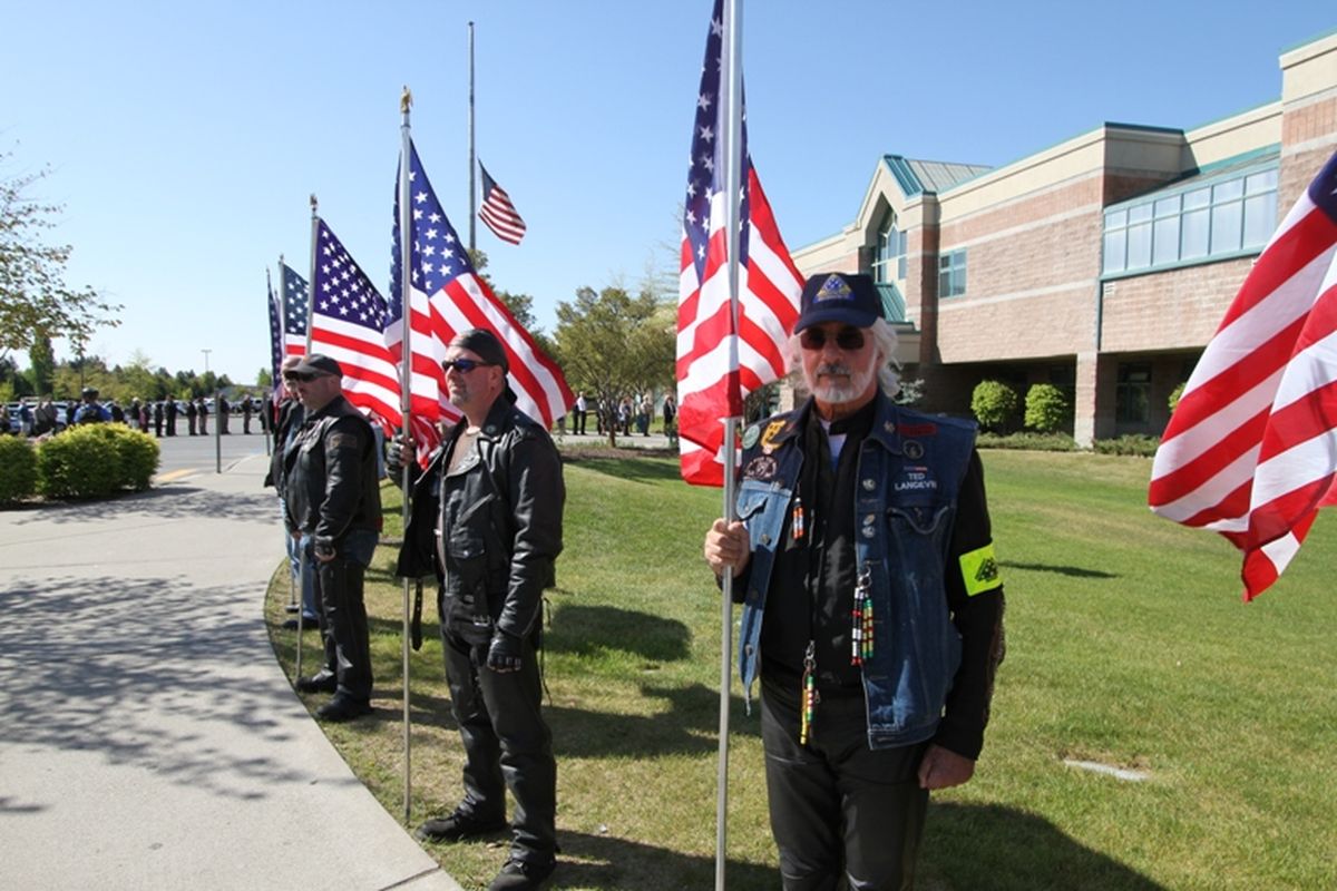 Patriot Guard Riders, with flag flying at half staff, greet mourners and hundreds of officers who attended today