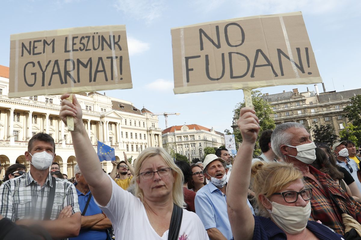 Protesters hold placards reading in Hungarian 