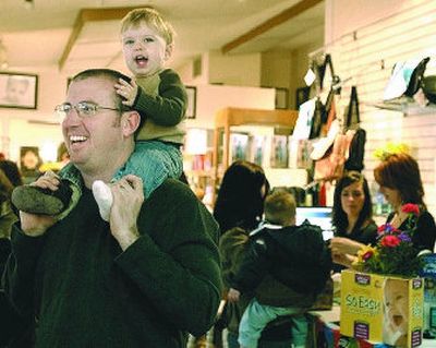 
Ashton Hoskinson, 1, of Spokane, gets a ride from his dad, Aaron, while his mom, Ginafer, shops at the Super Bowl sale at Mother's Haven, a Coeur d'Alene retailer specializing in baby and parent products. 
 (J. Bart Rayniak / The Spokesman-Review)