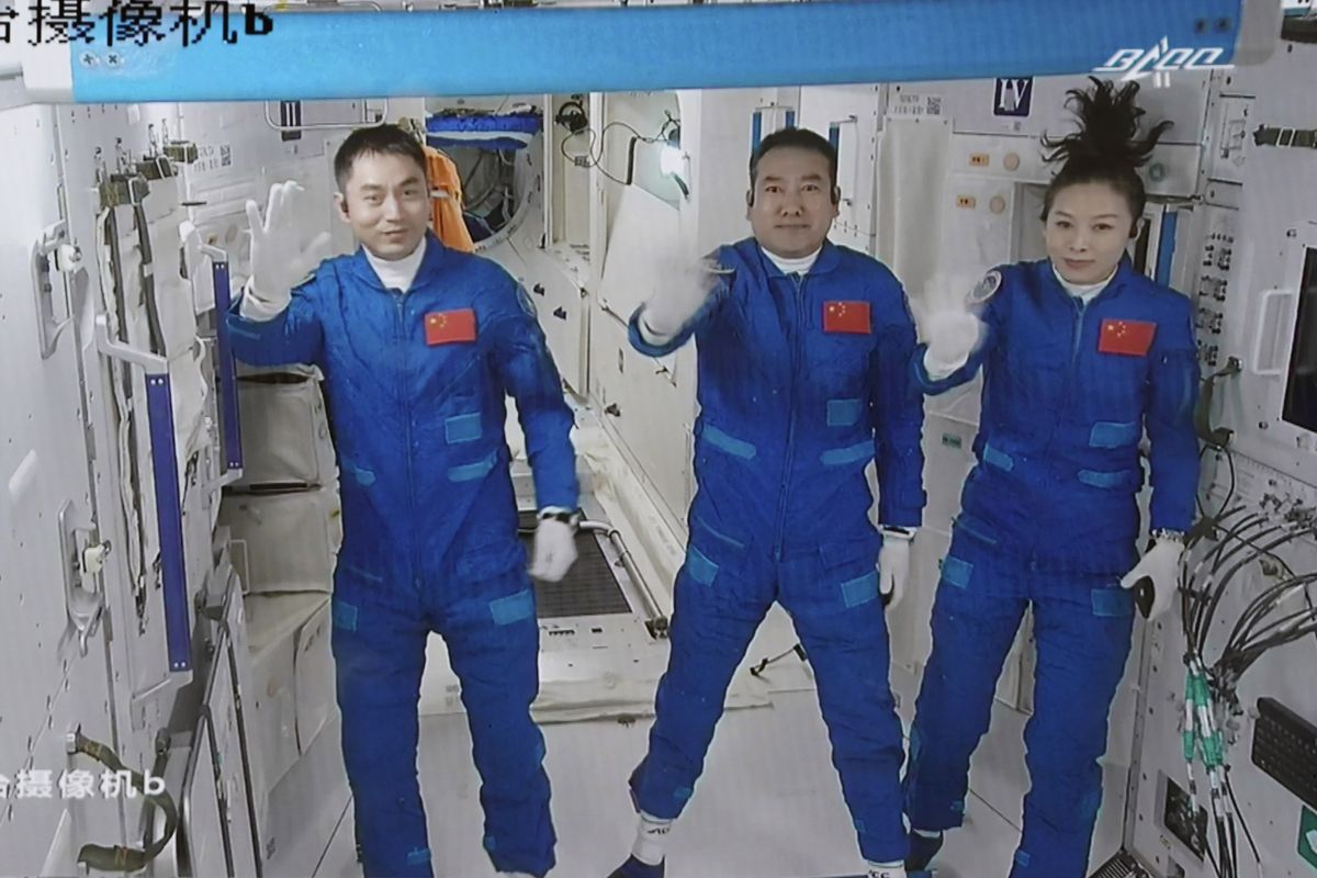 FILE - In this photo released by Xinhua News Agency, screen image captured at Beijing Aerospace Control Center in Beijing, China on Oct. 16, 2021, shows three Chinese astronauts, from left, Ye Guangfu, Zhai Zhigang and Wang Yaping waving after entering the space station core module Tianhe. Three Chinese astronauts returned to Earth on Saturday, April 16, 2022, after six months aboard China's newest space station in the longest crewed mission to date for its ambitious space program.  (Tian Dingyu)