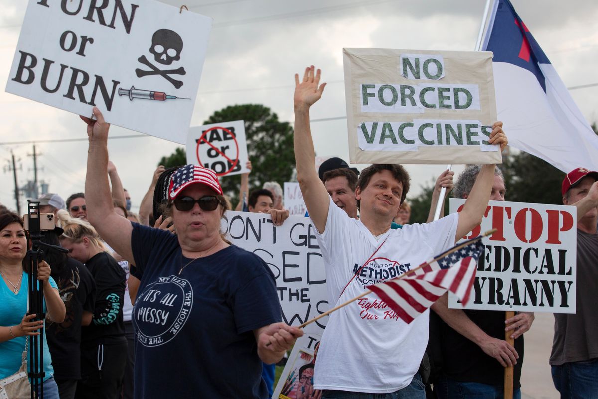Demonstrators at Houston Methodist Baytown Hospital June 7 in Baytown, Texas, wave at cars that honk at them to support their protest against a policy that says hospital employees must get vaccinated against COVID-19 or lose their jobs.  (Yi-Chin Lee)