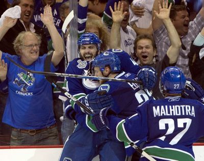 Vancouver Canucks right wing Maxim Lapierre celebrates with teammates Alexander Edler and  Manny Malhotra after scoring against the Boston Bruins during the third period of Game 5 of the Stanley Cup  finals in Vancouver, British Columbia on Friday, June 10, 2011. (Darryl Dyck / The Canadian Press)