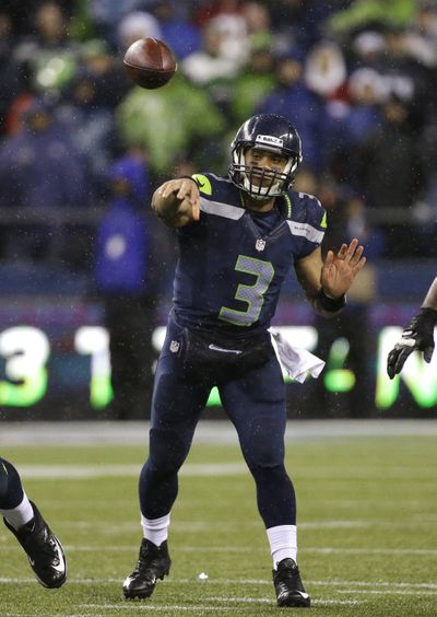 Seattle Seahawks quarterback Russell Wilson throws against the San Francisco 49ers in the first half on Sunday in Seattle. (Elaine Thompson / Associated Press)
