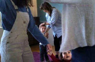 
Syringa Barent, 18 months, dances with her mother Juliet, left, and substitute teacher, Elizabeth Lund while Cody Mac Taylor, 2, dances with his mother Cari at the Holy Name's Music Center on Thursday. The day care teaches children music. A few of the toddlers will begin instrument lessons before the age of five. 
 (Jed Conklin photos/ / The Spokesman-Review)