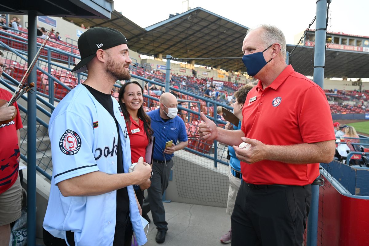 Seth Bendewald, left, is greeted by Otto Klein, right, senior vice president of the Spokane Indians, and other staff before Bendewald threw out the first pitch at the game Thursday, Aug. 18, 2021 at Avista Stadium. Bendewald served in the army in Afghanistan a decade ago.  (JESSE TINSLEY)