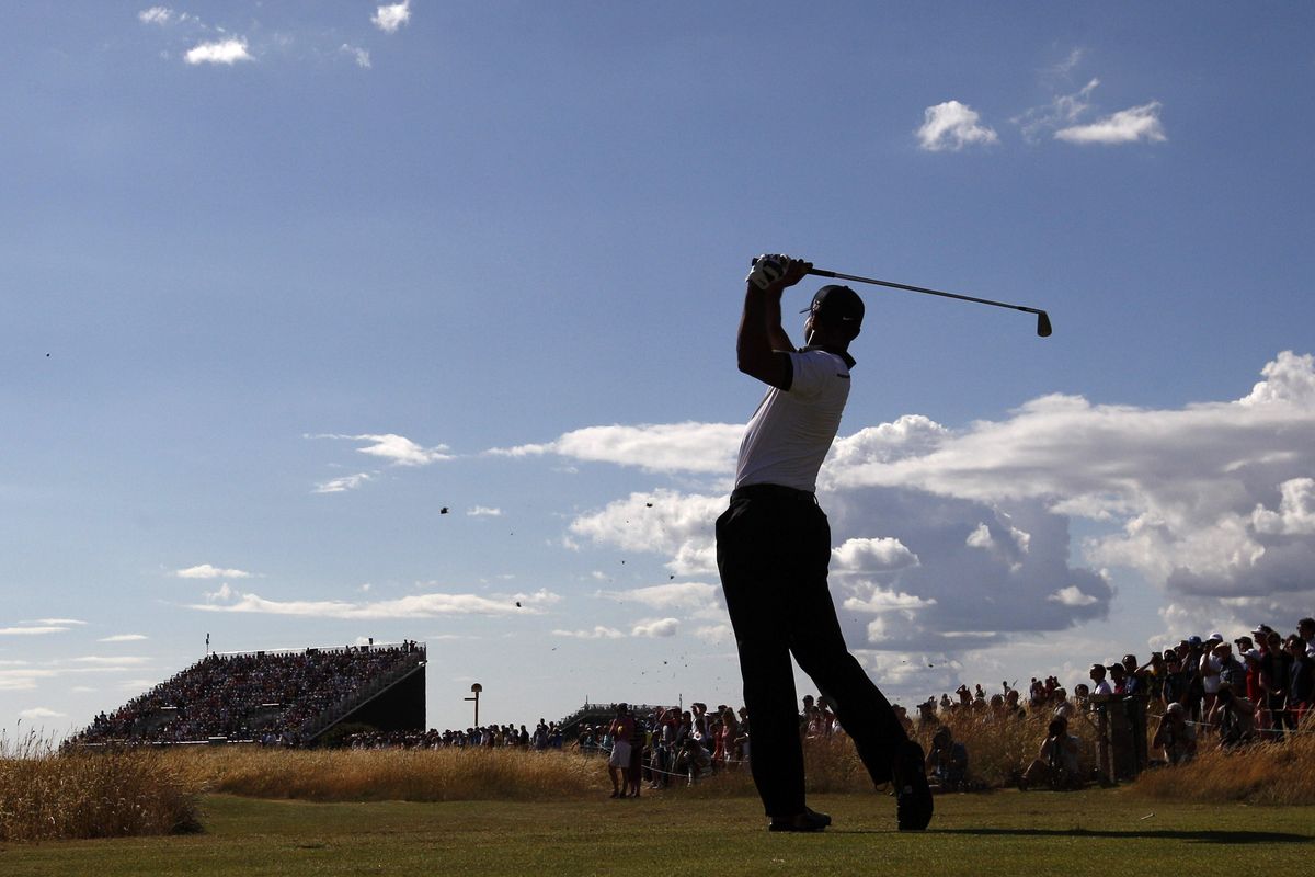 Tiger Woods, who shot a first-round 69, hits off the seventh tee during the first round of the British Open at Muirfield, Scotland. (Associated Press)