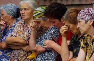 
Ossetian women sit waiting for news not far from the school seized by attackers in Beslan, North Ossetia, on Wednesday. As many as 400 people – many of them children – are being held hostage.
 (Associated Press / The Spokesman-Review)