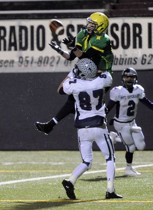 Shadle Park's Nick Kiourkas leaps and makes an aerial catch over Mt. Spokane's Dillon Madlener (87) in th endzone for a touchdown Friday, Nov. 15, 2013 during their playoff game at Joe Albi Stadium. (Jesse Tinsley / The Spokesman-Review)