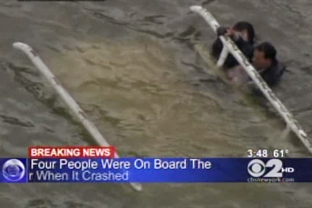 In this frame grab image taken from WCBS-TV, survivors cling to the bottom of a helicopter after it inverted following a crash in the East River in New York, Tuesday Oct. 4, 2011. The New York Police Department says the helicopter with five people aboard crashed into the river after taking off from a nearby heliport. The pilot and three others were pulled from the water shortly by rescue crews after it went down. Authorities were still searching for one other passenger, believed to be female, but the helicopter was fully submerged. (WCBS TV)