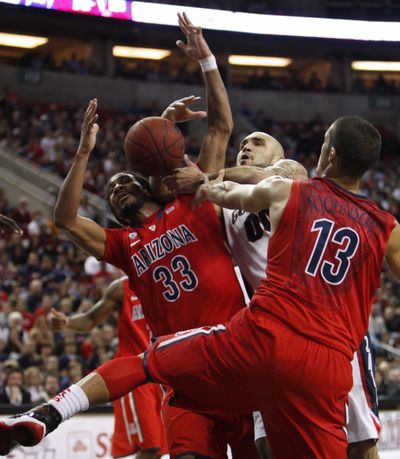 Arizona'sJesse Perry, left, and Nick Johnson, right, rebound as Gonzaga's Robert Sacre, center, loses control of the ball during first half of an NCAA college basketball game in Seattle, Saturday, Dec. 17, 2011. (Kevin Casey / Fr132181 Ap)