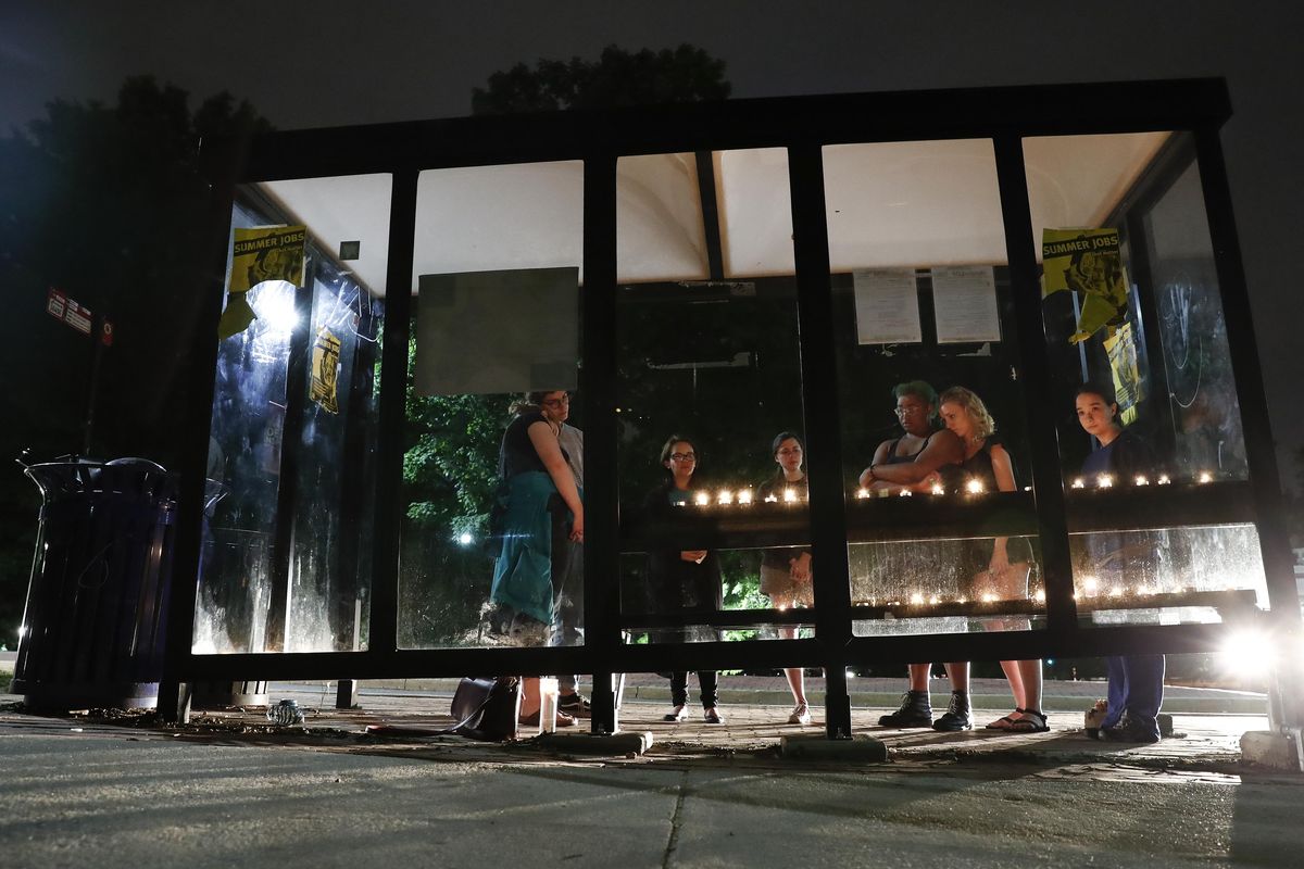 People gather for a candlelight vigil at a bus shelter at the University of Maryland in College Park, Md, Sunday, May 21, 2017, where visiting student was fatally stabbed. A University of Maryland student was charged Sunday with fatally stabbing a visiting student on campus in what police have described as an unprovoked attack that rattled the school over graduation weekend. (Carolyn Kaster / Associated Press)