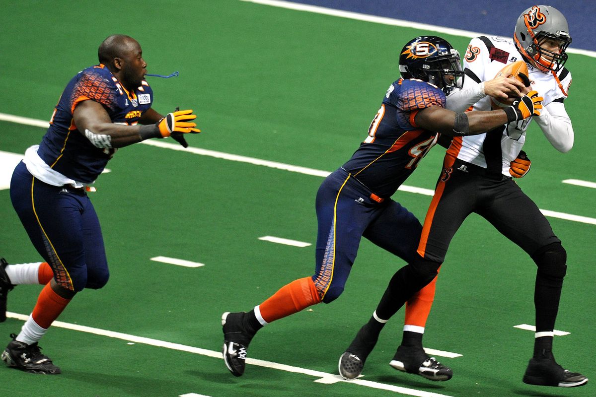 Shock lineman Mike Alston (40) sacks Utah Blaze quarterback Tommy Grady (10) as fellow lineman Jonathan Williams pursues helmetless during the first half of an AFL game on Sunday, June 17 in Spokane. (Tyler Tjomsland)