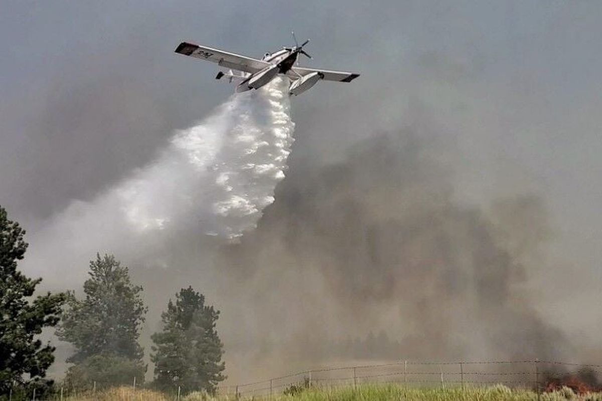 An water-dropping airplane finds its target Monday afternoon to help firefighters control a fast moving brush fire southwest of Spokane.  (Spokane Valley Fire Department)