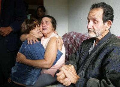 
A relative comforts Maria Otone de Menezes, center, and Matuzinho de Menezes, mother and father of Jean Charles de Menezes, at their home near Gonzaga, Brazil, on Sunday. 
 (Associated Press / The Spokesman-Review)